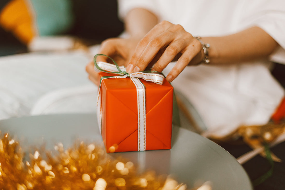 manos envolviendo un regalo