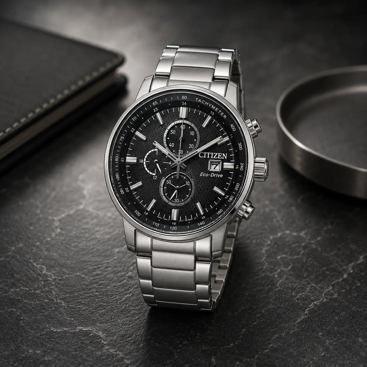  Reloj cronógrafo de hombre Citizen Chrono Eco-Drive CA0840-87E de acero inoxidable con esfera negra texturizada e indicadores de taquímetro en plano detalle.