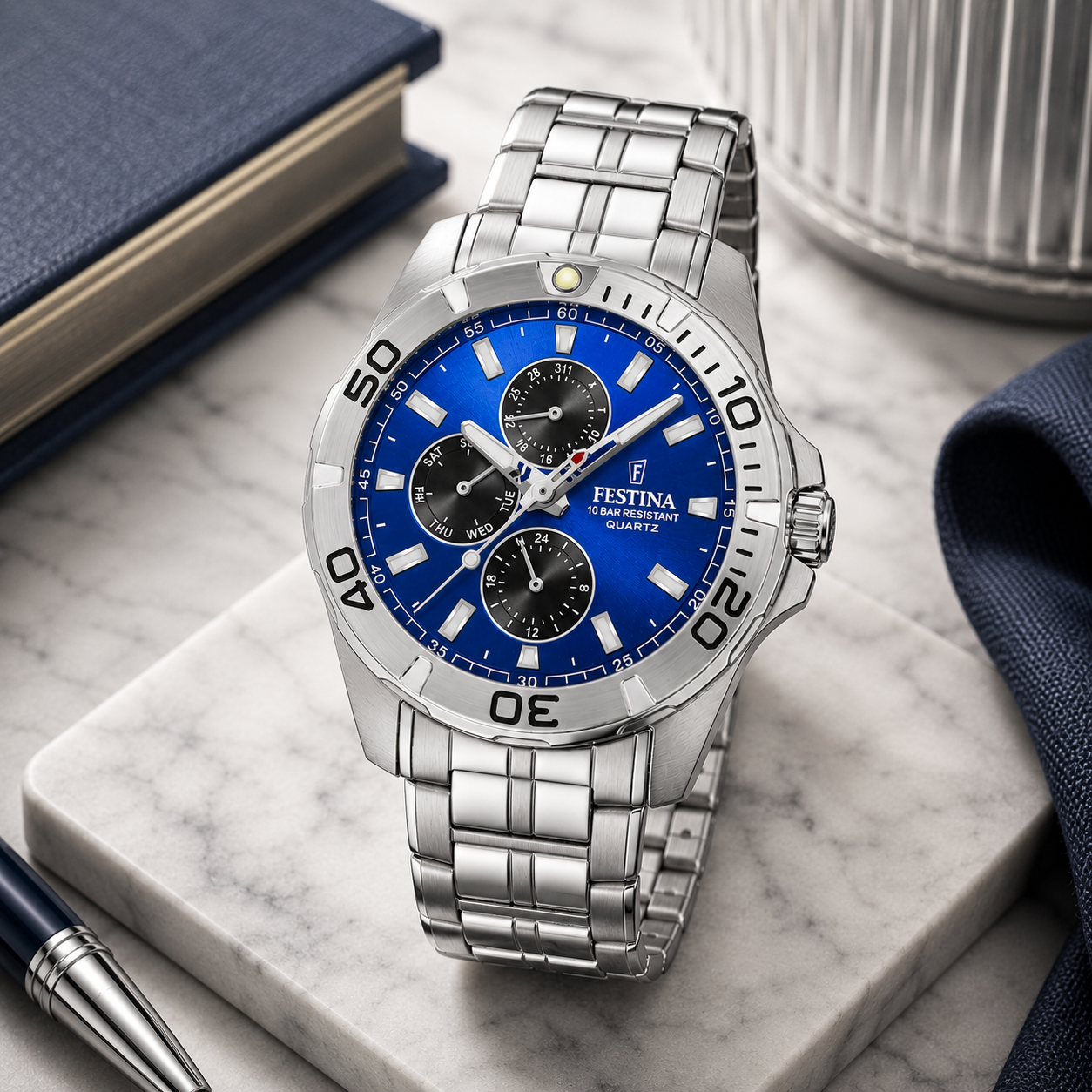 Reloj multifunción para hombre Festina Sport F20445/5 de acero inoxidable plateado con esfera azul cobalto y bisel de buceo sobre mármol blanco.