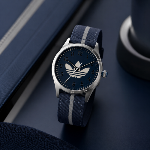 Reloj deportivo Adidas Code Four AOSY23041 con caja plateada de acero, dial azul marino con el gran logo del trébol y correa azul con franja gris central.