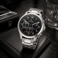 Reloj de hombre Tommy Hilfiger Asher 1791852 cronógrafo de acero inoxidable plateado sobre un cojín de cuero negro con esfera negra.