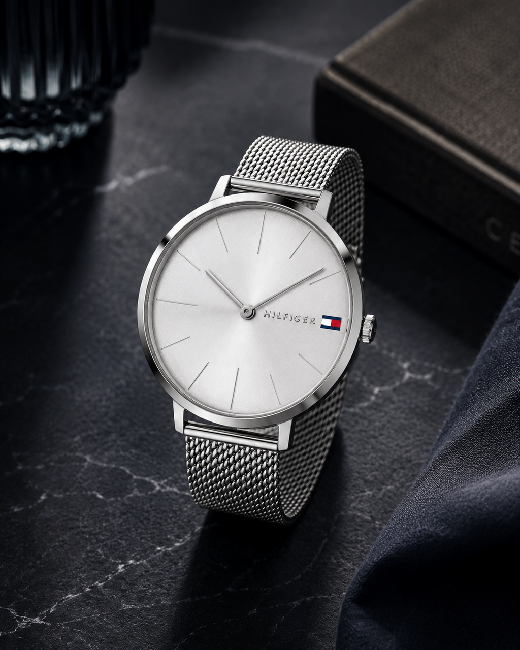  Reloj de mujer Tommy Hilfiger Alexa 1782163 plateado con correa de malla milanesa y esfera minimalista sobre superficie de mármol negro.
