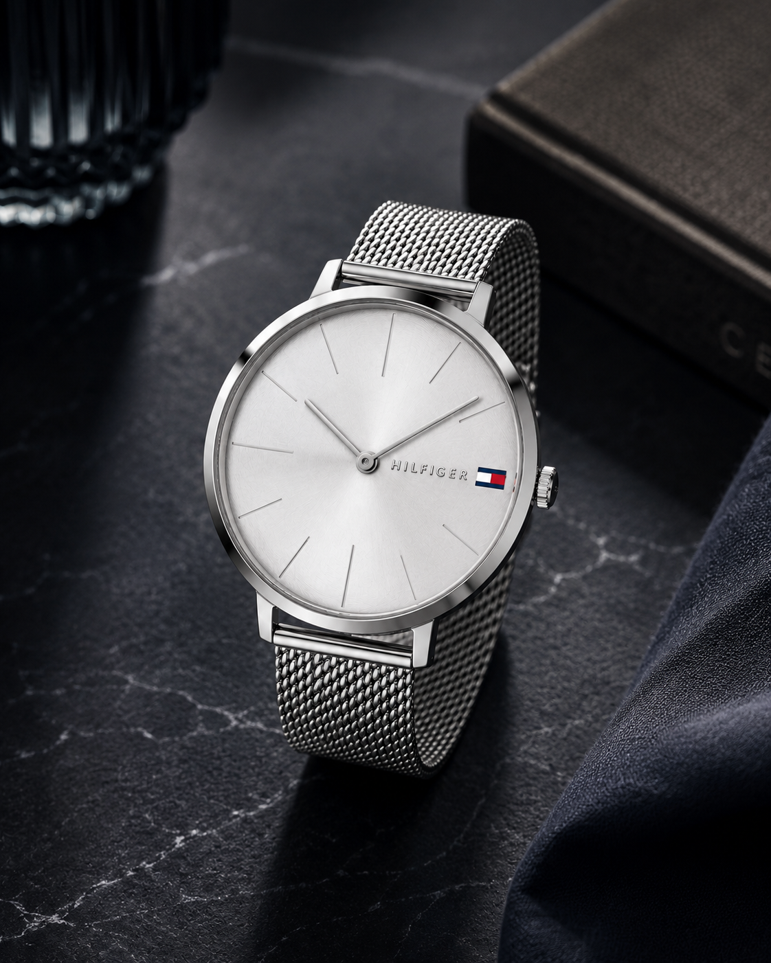  Reloj de mujer Tommy Hilfiger Alexa 1782163 plateado con correa de malla milanesa y esfera minimalista sobre superficie de mármol negro.