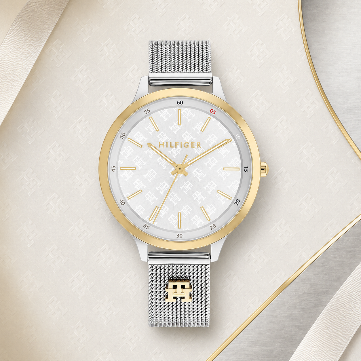  Reloj de mujer Tommy Hilfiger Iris 1782586 bicolor plateado y dorado con esfera blanca grabada con el monograma TH y correa de malla milanesa.