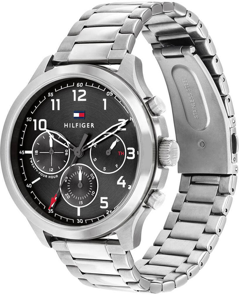 Reloj de hombre Tommy Hilfiger Asher 1791852 cronógrafo de acero inoxidable plateado sobre un cojín de cuero negro con esfera negra.