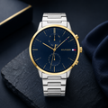 Reloj de hombre Tommy Hilfiger Hunter 1710408 de acero inoxidable plateado con bisel dorado, esfera azul marino y subesferas indicadoras.