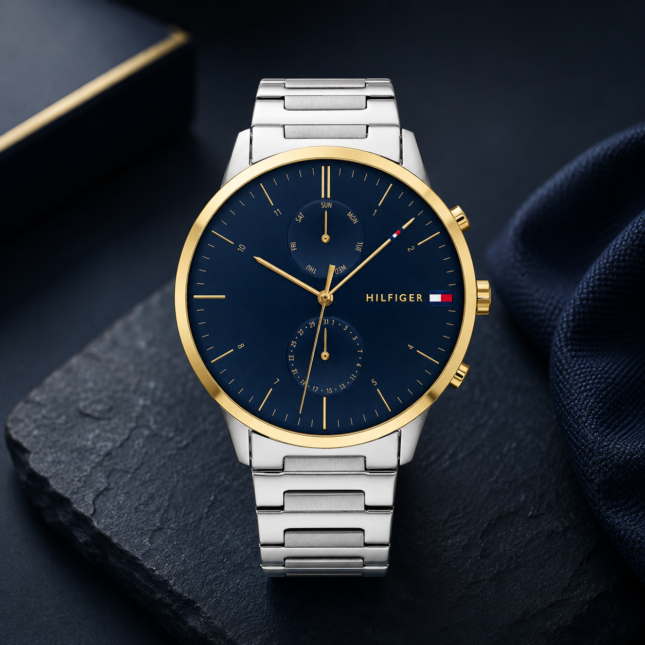 Reloj de hombre Tommy Hilfiger Hunter 1710408 de acero inoxidable plateado con bisel dorado, esfera azul marino y subesferas indicadoras.